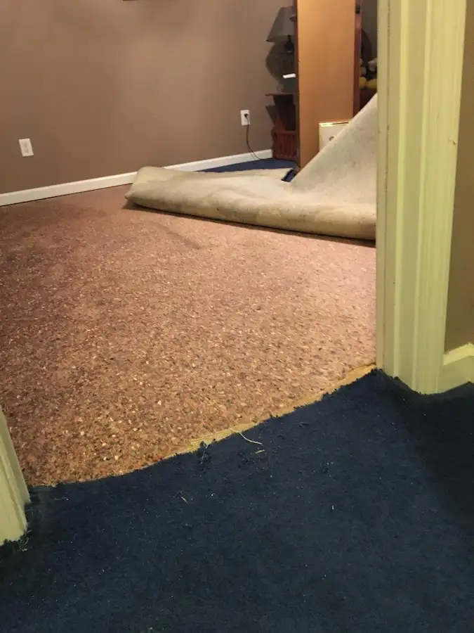 Carpet pad removal revealing water damage during Water Mitigation Services in Pound Ridge